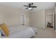A neutral-toned bedroom has a ceiling fan and entry into the Primary bath at 17860 Passionflower Cir, Clermont, FL 34714