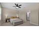 Bedroom with neutral color walls, ceiling fan and a doorway that leads into a brightly lit bathroom at 17860 Passionflower Cir, Clermont, FL 34714