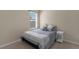 Cozy bedroom with soft blue bedding, decorative pillows, and a window at 17860 Passionflower Cir, Clermont, FL 34714