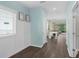 Inviting entryway with coat storage nook, light blue walls and adjacent view into a living and dining space at 17860 Passionflower Cir, Clermont, FL 34714