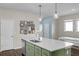 A kitchen island with a sink and a dishwasher with cabinets painted green below a white countertop at 17860 Passionflower Cir, Clermont, FL 34714