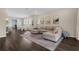 Open-concept living room adjacent to a modern kitchen and dining area, featuring hardwood floors and stylish decor at 17860 Passionflower Cir, Clermont, FL 34714