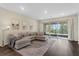 Cozy living room with a large sectional sofa and sliding doors leading to a balcony with a view at 17860 Passionflower Cir, Clermont, FL 34714