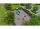 Aerial view of a green playground with a slide, spring riders, and shade trees at 17860 Passionflower Cir, Clermont, FL 34714