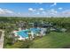 Aerial view of community pool and clubhouse, featuring palm trees, manicured lawns and plenty of space for recreation at 17860 Passionflower Cir, Clermont, FL 34714