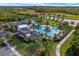 Aerial view of a pool and clubhouse surrounded by lush landscaping and a walking path at 17860 Passionflower Cir, Clermont, FL 34714
