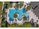 An aerial view of a resort-style pool with palm trees and ample lounge chairs at 17860 Passionflower Cir, Clermont, FL 34714