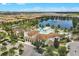 Expansive aerial view of community pool, clubhouse, and amenities surrounded by lush greenery and a serene lake at 1935 Majorca Dr, Kissimmee, FL 34747