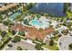 Beautiful aerial view of the community pool, clubhouse, and amenities adjacent to a serene lake at 1935 Majorca Dr, Kissimmee, FL 34747