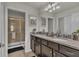 Elegant bathroom with double sinks, granite countertops, and a walk-in shower at 1935 Majorca Dr, Kissimmee, FL 34747