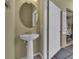 A pedestal sink and large round mirror add elegance to this outdoor accessible bathroom at 1935 Majorca Dr, Kissimmee, FL 34747