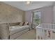 Cozy bedroom with a trundle bed, crib, and patterned wallpaper, perfect for a Bedroom at 1935 Majorca Dr, Kissimmee, FL 34747