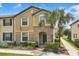 Inviting two-story townhome featuring a well-manicured lawn and a beautiful palm tree in the front yard at 1935 Majorca Dr, Kissimmee, FL 34747