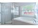 Bathroom featuring a corner tub, separate shower, and large window at 2031 Gloria Oak Ct, Orlando, FL 32820