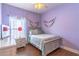 Cozy bedroom with wood floors, a gray bed frame, and bright purple walls at 2031 Gloria Oak Ct, Orlando, FL 32820