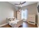 Bright bedroom with wood floors, ceiling fan, white furniture, and window at 2031 Gloria Oak Ct, Orlando, FL 32820