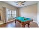 A billiard room with a ceiling fan and a large window for natural lighting at 2031 Gloria Oak Ct, Orlando, FL 32820