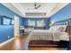 Spacious bedroom with hardwood floors, tray ceiling, large bed, and an office nook at 2031 Gloria Oak Ct, Orlando, FL 32820