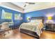 Bright main bedroom with hardwood floors, tray ceiling, and large bed at 2031 Gloria Oak Ct, Orlando, FL 32820