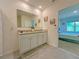 A bathroom with a double sink vanity, granite countertops, and an adjacent bedroom at 2033 E Gloria Dr, Deltona, FL 32725