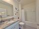 Well-lit bathroom featuring a single sink vanity with granite countertop, and tub with shower at 2033 E Gloria Dr, Deltona, FL 32725