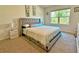 Comfortable bedroom with plush carpeting, a stylish upholstered bed, and ample natural light at 2033 E Gloria Dr, Deltona, FL 32725