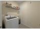 Efficient laundry room with modern washer and overhead shelving for storage at 2033 E Gloria Dr, Deltona, FL 32725