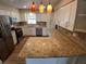Modern kitchen with white cabinets, granite countertops, stainless steel appliances, and stylish pendant lights at 2414 Willow Oak Dr, Edgewater, FL 32141