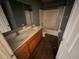 Bathroom with double sinks, wood-look flooring, and a tub/shower combo with a shower curtain at 266 Vervain Ave, Davenport, FL 33837