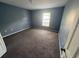 Bedroom with neutral carpeting, paint, and a window letting in plenty of natural light at 266 Vervain Ave, Davenport, FL 33837