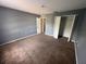 Bedroom featuring neutral carpeting, paint, closet, and an attached bathroom at 266 Vervain Ave, Davenport, FL 33837