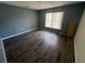 An empty bedroom with wood-look floors and a double-hung window for natural light at 266 Vervain Ave, Davenport, FL 33837