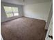 Bedroom with neutral carpeting, paint, and a window letting in plenty of natural light at 266 Vervain Ave, Davenport, FL 33837