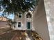 Close-up of a two-story home's front exterior featuring a green front door with sidelights and an arched window above at 266 Vervain Ave, Davenport, FL 33837