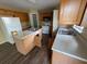 This kitchen offers wood cabinets, a kitchen island with a sink, a white refrigerator, and hard wood floors at 266 Vervain Ave, Davenport, FL 33837