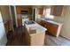 This kitchen features wood cabinets, an island with a sink, a white refrigerator, and hardwood floors at 266 Vervain Ave, Davenport, FL 33837
