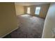 Living room featuring neutral carpeting, paint, and two windows letting in plenty of natural light at 266 Vervain Ave, Davenport, FL 33837
