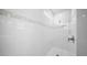 A white tiled shower with a shower head and grab bar installed at 2698 River Creek Ln, St Cloud, FL 34771
