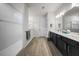 Bright bathroom featuring double sink vanity, tiled shower, and hardwood floors at 2698 River Creek Ln, St Cloud, FL 34771