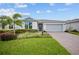 Beautiful one-story home with lush landscaping, brick-paved driveway, and an attached two-car garage at 2698 River Creek Ln, St Cloud, FL 34771