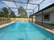 Backyard pool with jacuzzi featuring screened enclosure and view of home at 3055 Kirkland St, Deltona, FL 32738