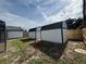 The backyard showcases two white storage sheds with black trim and fenced perimeter at 3055 Kirkland St, Deltona, FL 32738
