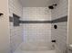 Shower with new white subway tile, dark bronze fixtures, and decorative accent tiles at 3055 Kirkland St, Deltona, FL 32738