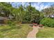 Serene backyard features an outdoor seating area and a brick path surrounded by lush greenery at 315 Desoto Cir, Orlando, FL 32804