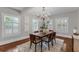 Bright dining room with chandelier, wood floors, three windows, and a neutral rug at 315 Desoto Cir, Orlando, FL 32804