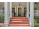 Welcoming front porch with brick steps, stately columns, and potted flowers at the entry at 315 Desoto Cir, Orlando, FL 32804