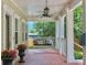 Inviting covered porch features a swing seat, ceiling fan, and potted flowers at 315 Desoto Cir, Orlando, FL 32804