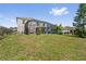 Backyard with lush green grass and a screened-in patio overlooking a neighboring property at 328 Fairfield Dr, Sanford, FL 32771