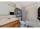 Bathroom with wood vanity, sink, toilet and shower with curtain at 328 Fairfield Dr, Sanford, FL 32771