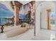 Bathroom with a soaking tub, mural, and marble floors, offering a luxurious experience at 328 Fairfield Dr, Sanford, FL 32771